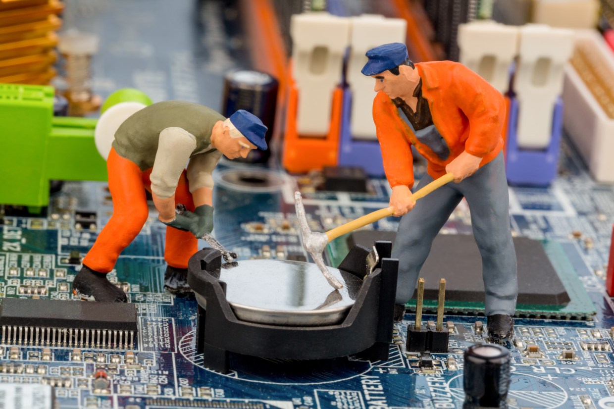 workers repairing computer motherboard