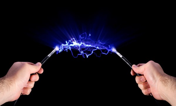 Stock image of  hands holding live electric cables