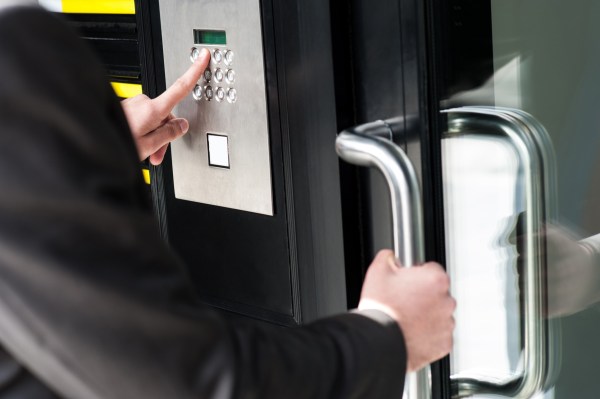 Businessman entering safe code to unlock the door.