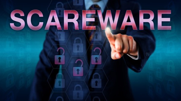 Management user is touching SCAREWARE on a screen. Three cracked lock icons are highlighted to represent compromised or malicious software code. Computing technology concept and business metaphor.