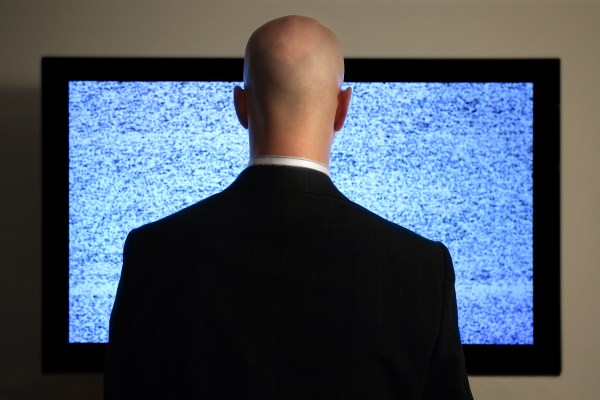 A man watching a screen with unwanted content