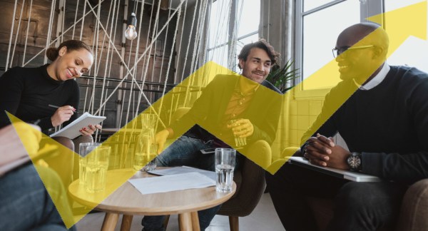 Relaxed young executives having a meeting indoors. Multiracial group of people sitting in office lobby discussing business.