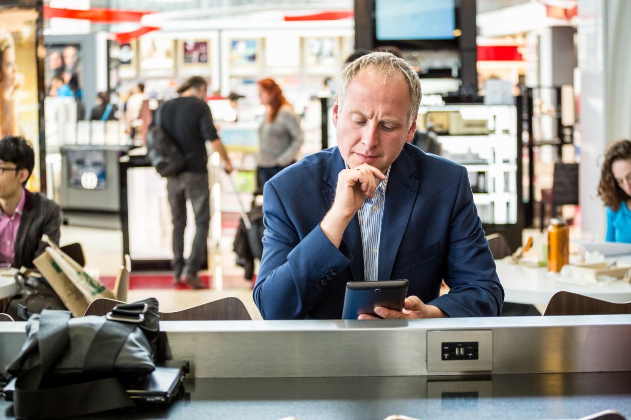 Businessman using his tablet waiting at the airport