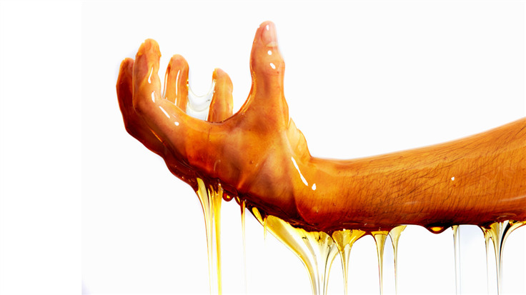 human hand dripping honey