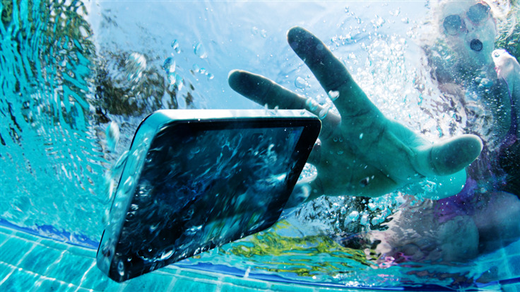person reaching for a mobile phone that has fallen into water
