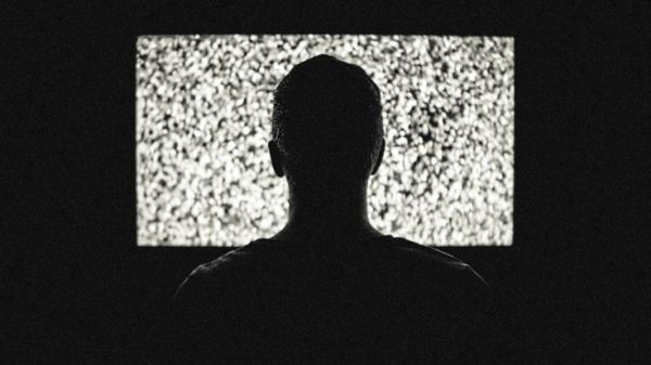 Back of a person's head watching a static screen