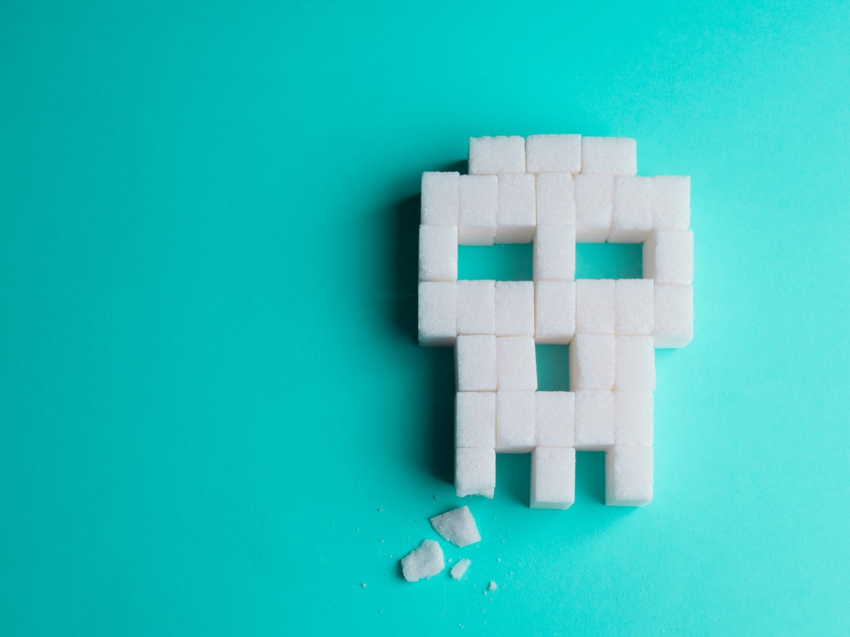skull made of sugar cubes with a broken tooth. Concept of tooth decay.