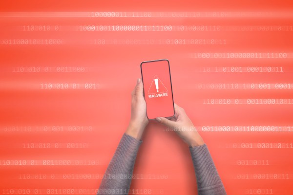 Malware alert notification on mobile phone. Female hands holding gadget with warning message on screen