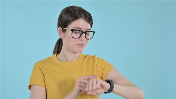 Young Woman Using Apple Watch on Purple Background