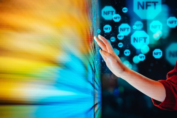 Close up of woman's hand touching colourful and illuminated LED display screen, working with blockchain technologies, investing or trading NFT (Non-Fungible Token) on cryptocurrency, digital asset, art work and digital ledger