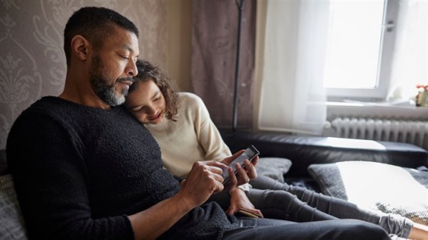 father and daughter looking at a smartphone