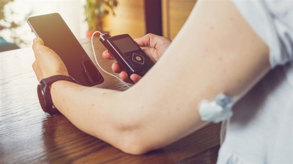 person using insulin pump with smartphone