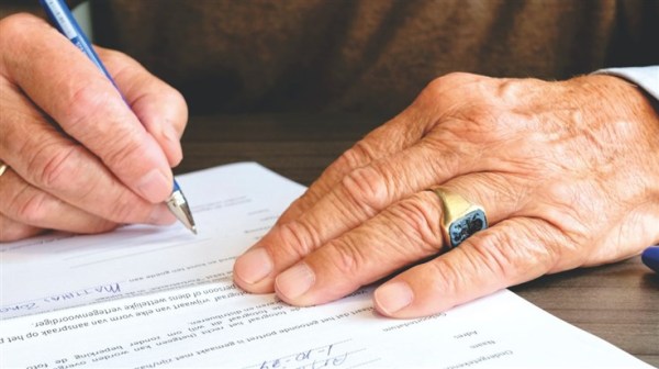 A man signing a document.
