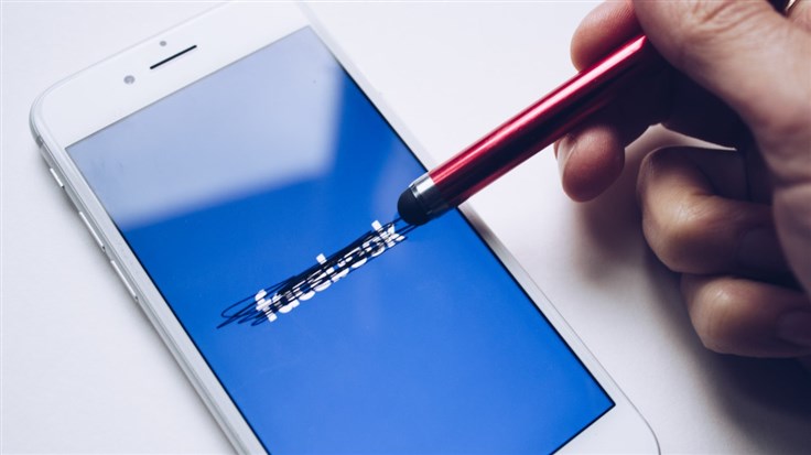 Facebook logo being rubbed out on smartphone