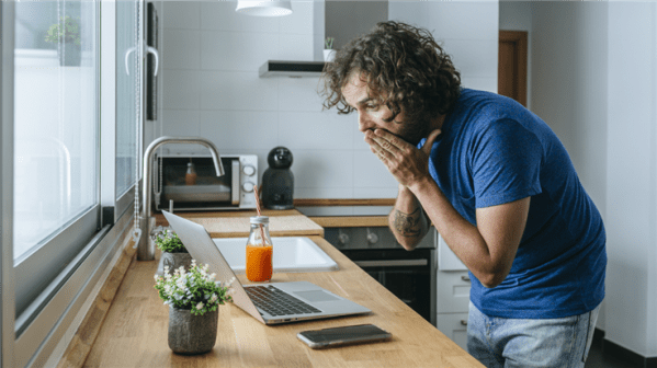 man looking surprised at laptop