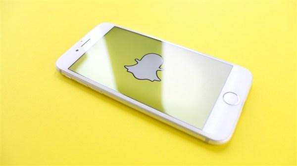 Snapchat logo on phone yellow background