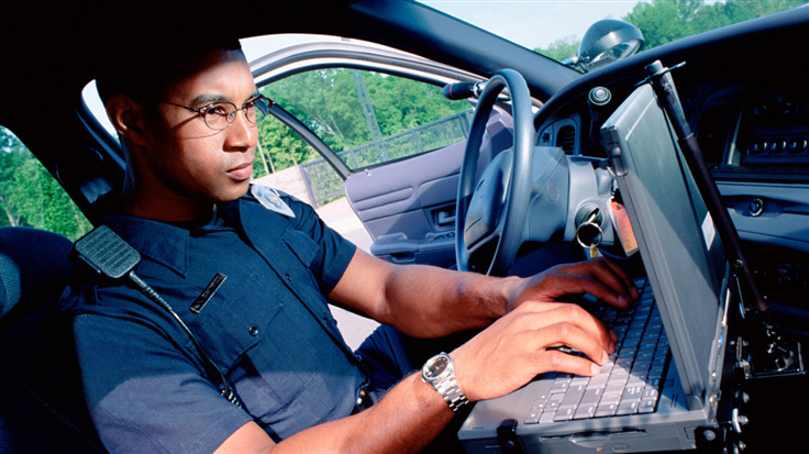 Law enforcement officer using a laptop