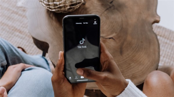 person holding phone with TikTok name and logo