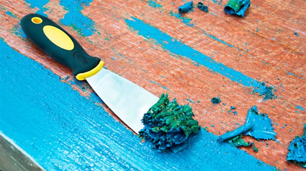 scraping tool removing blue paint from wood