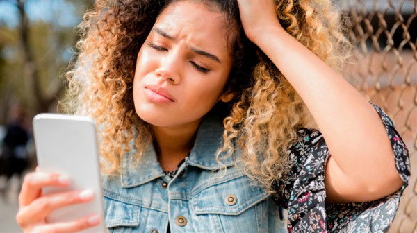 woman looking resigned at her phone