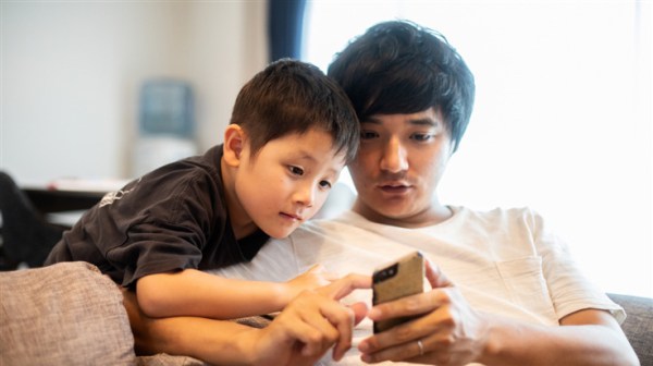 father and son looking at a smartphone