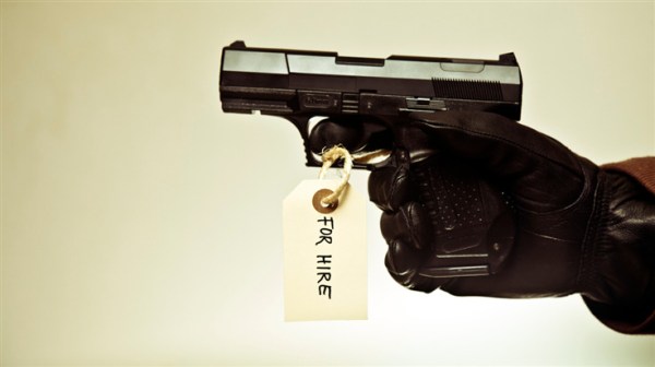 gloved hand holding a toy gun with a for hire tag