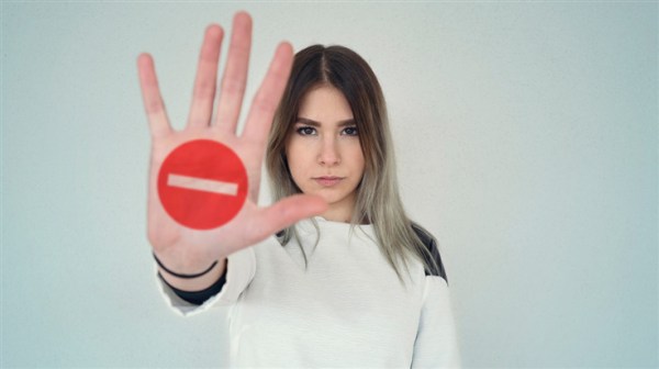 A woman holding out a stop sign