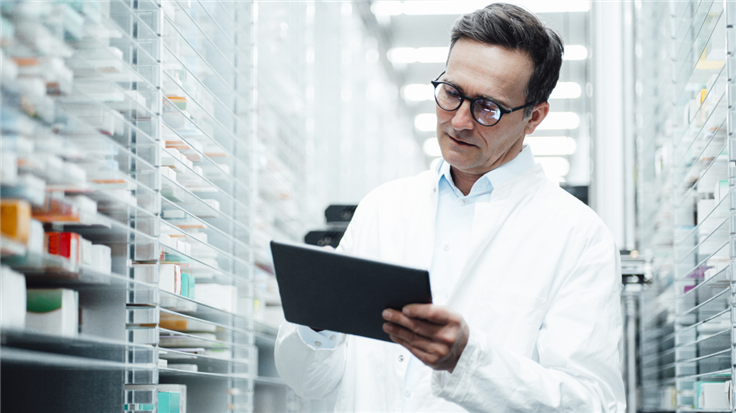 a pharmacist looking at a tablet