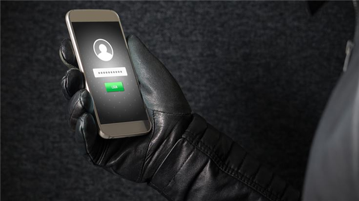 A gloved hand holding a secured phone