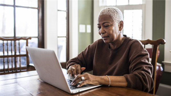 grey haired woman busy on her laptop