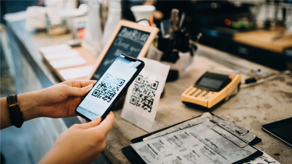 Hands holding a phone to scan a QR code