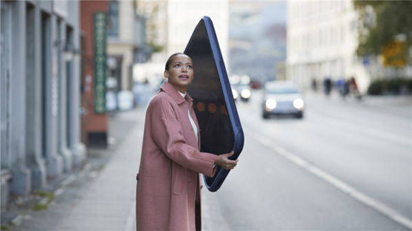 Woman talking on huge phone on the sidewalk