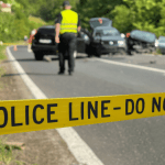 Police tape across the scene of a car accident