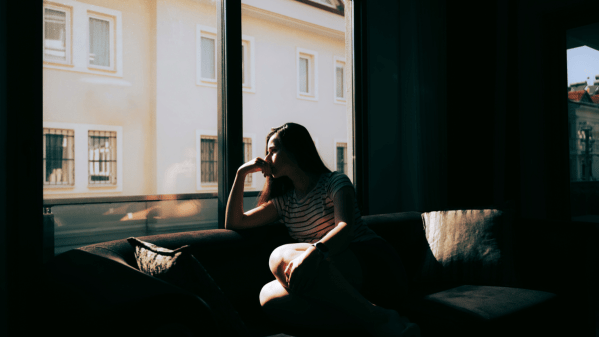 Woman sat in front of a window looking out