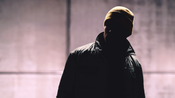 Man in the dark wearing a hat