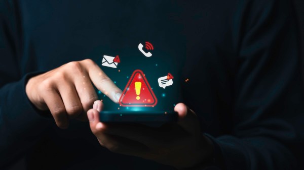 A person is holding a phone that is emitting many warning notifications, including an exclamation mark.