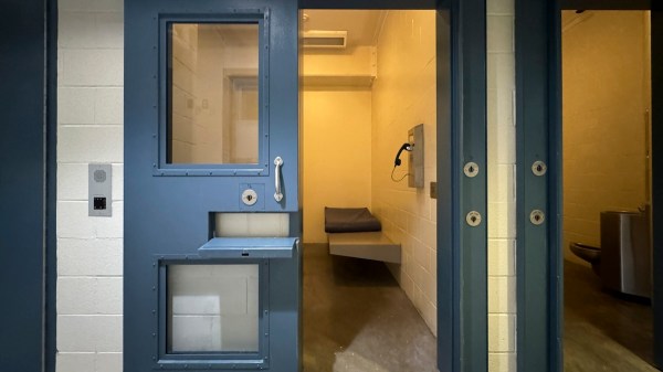 A prison cell with its sliding metal door opened to the left