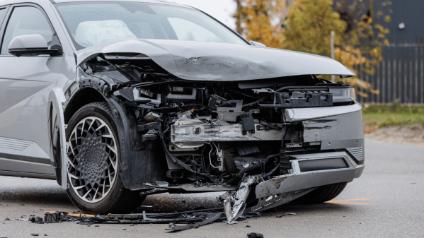 Dark colored car which has suffered an accident to the front of it and is damaged