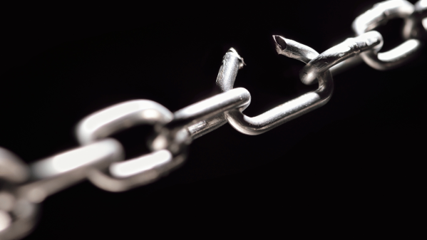 A broken metal chain on a black background