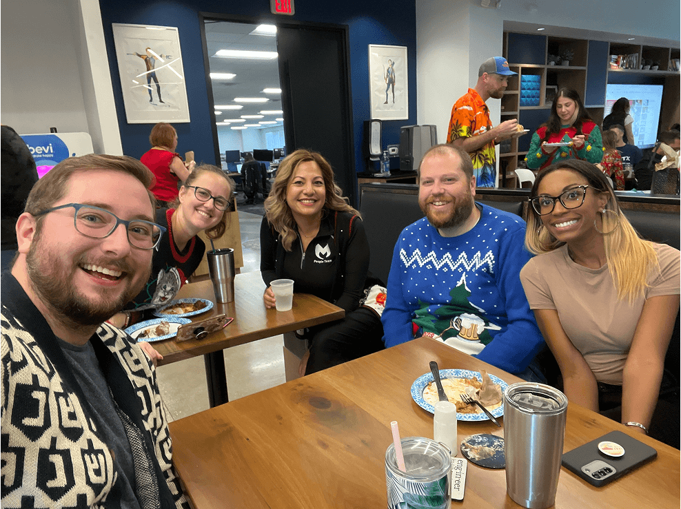 Picture of several Malwarebytes employees socializing in the office kitchen