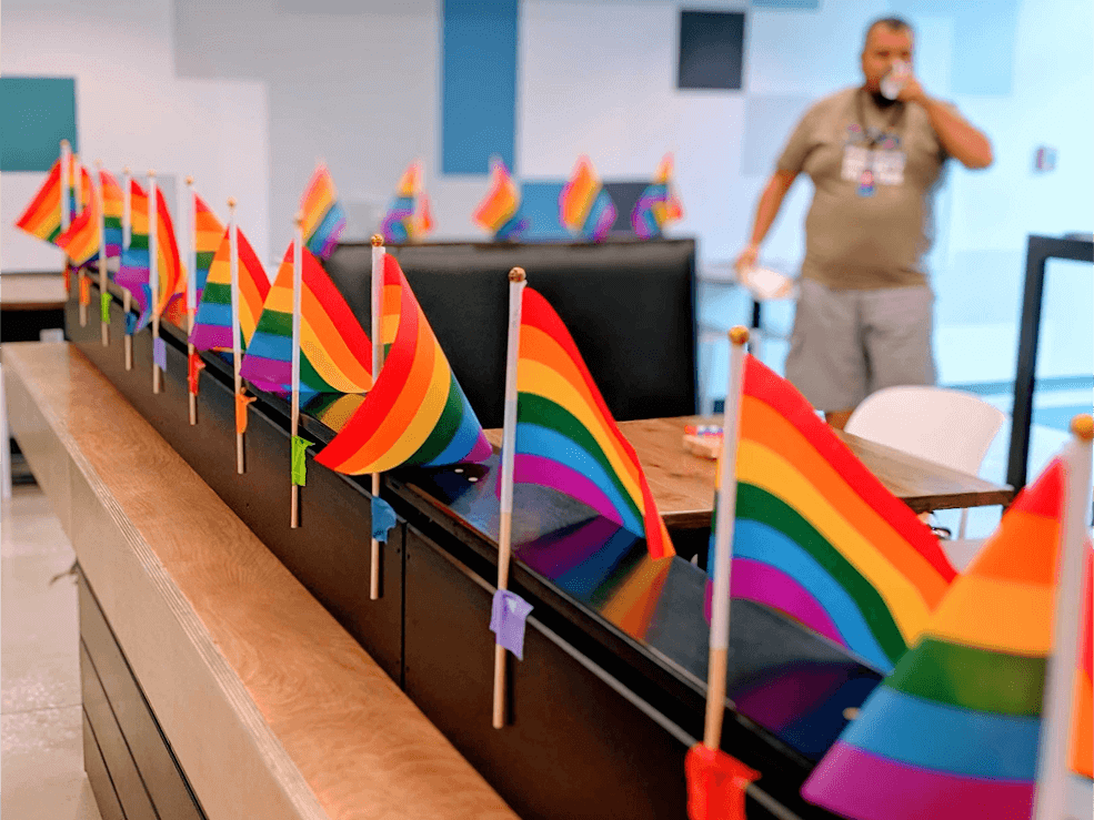 Photo of small rainbow flags attached to a desk