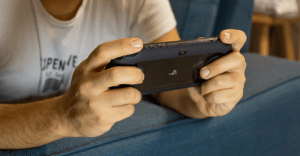 Close up of a man's hands playing the PlayStation Vita