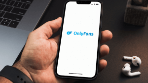 Only fans logo on a phone held in a male hand